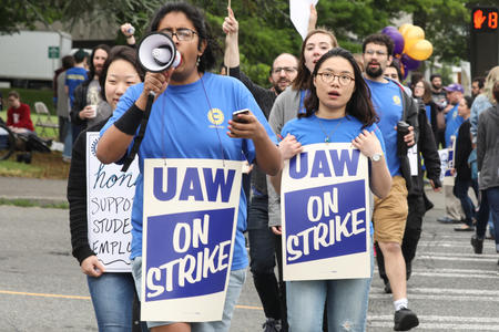 Students march across the intersection of Pend Oreille Street and Montlake Boulevard NE during one-day strike with graduate students who are represented by UAW Local 421 at the University of Washington in Seattle, May 14, 2018