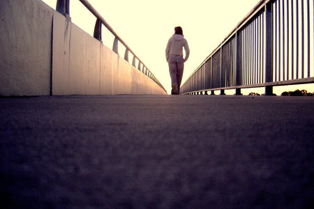 Lonely Girl walking along Bridge