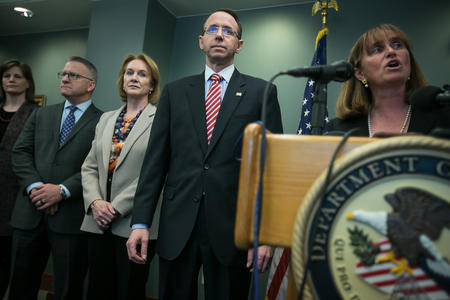 Local and federal law enforcement officials gather around a podium for a press conference at the U.S. Attorney's Office in Seattle.