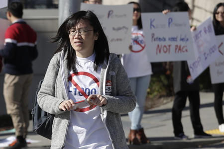 Linda Yang wears a shirt that draws a line through I-1000 at a protest against the initiative.
