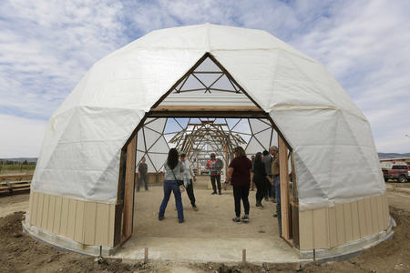 Dan Nanamkin and others inside a geodesic dome under construction 