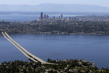 a panoramic view of lake washington, the i-90 bridge, and seattle skyline in the background
