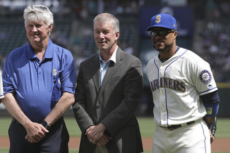 Seattle Mariners owner and chairman John Stanton, left, and President Kevin Mather, center, stand with Robinson Cano during a ceremony before a baseball game against the Los Angeles Angels, Sunday, May 6, 2018, in Seattle. (AP Photo/Ted S. Warren)