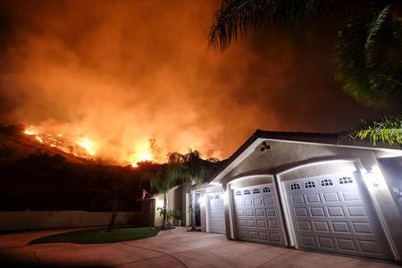 Flames shoot from a home in Lake Elsinore, Calif. 