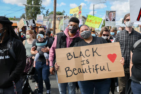 demonstrators hold a sign reading "Black is Beautiful"
