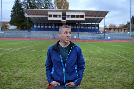 Former Bremerton High School assistant football coach Joe Kennedy stands in the middle of a football field.