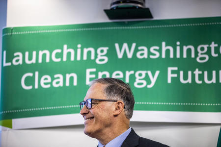 Gov. Jay Inslee in front of a banner that reads "Launching Washington's Clean Energy Future"