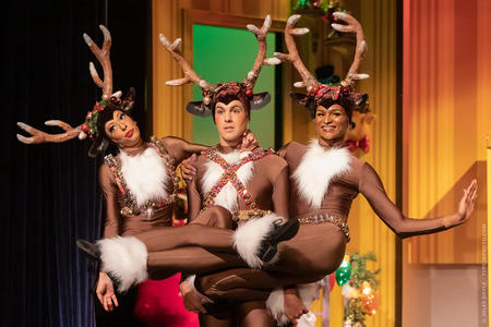 three actors dressed as festive holiday reindeer
