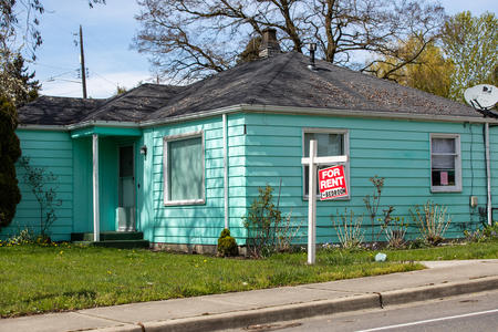 a teal home with a for rent sign on the lawn outside in Skyway, Washington
