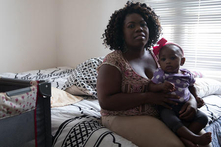 Turkessa Burrows holds her 10-month-old daughter Faith Campbell inside their apartment at the Oleta Apartments building in Seattle, Aug. 13, 2018. (Matt M. McKnight/Crosscut)