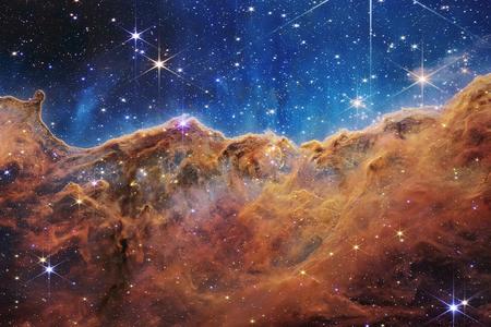 a NASA image from deep space that looks like a ruddy mountain range against a starry sky