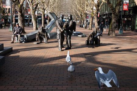 An empty pioneer Square in Seattle in front of firefighter statutes