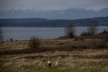 two people walking at Discovery Park near the water 