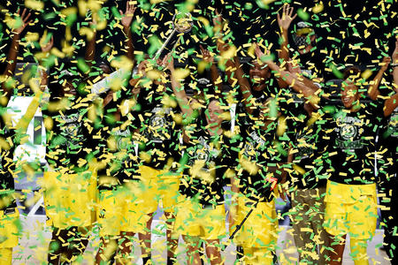 Seattle Storm players jump in the midst of a confetti cloud