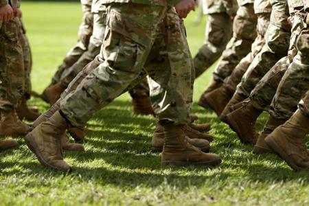 The boots of service members are shown as they march in unison.