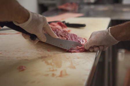 Worker cutting meat