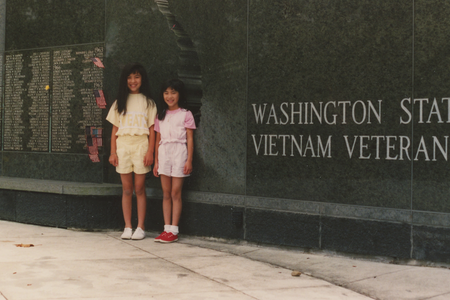 Two girls standing in front of a Vietnam veterans memorial