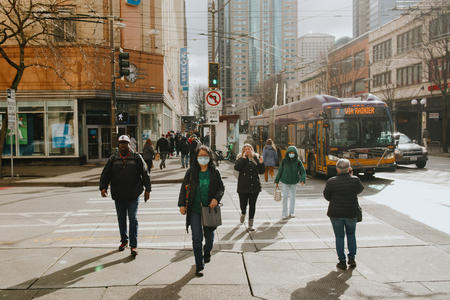 a group of people cross the street in downtown seattle surrounded by buidlings