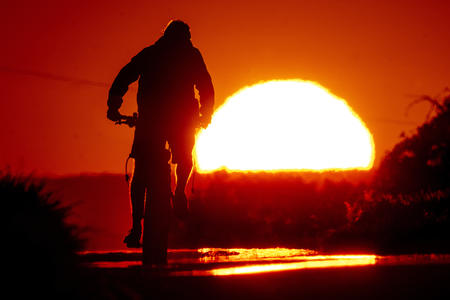 Person on a bike in front of a sunset