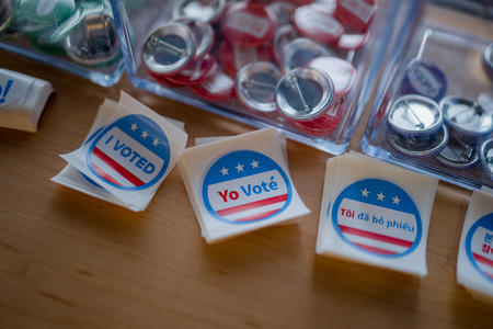 buttons and stickers saying "i voted" sit on a table
