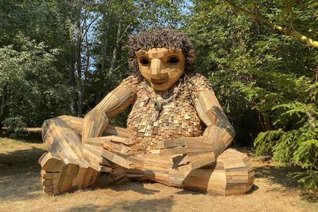 sculpture of a giant, seated troll, made of individual wooden planks