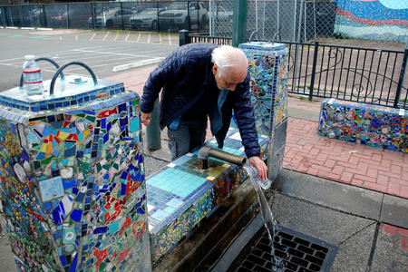 Tumwater resident Donnie Thompson fills water bottles at a free public well in Olympia's Artesian Commons park. 