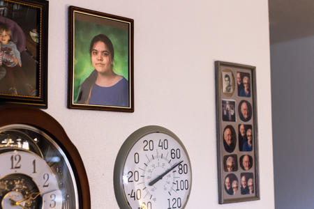 A wall with family photos and a clock.