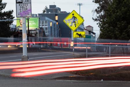 A photo of red light streaks from a passing car in front of the intersection of North 45th and Aurora Avenue North.