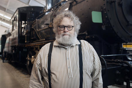 Knute Berger standing in front of a steam locomotive.
